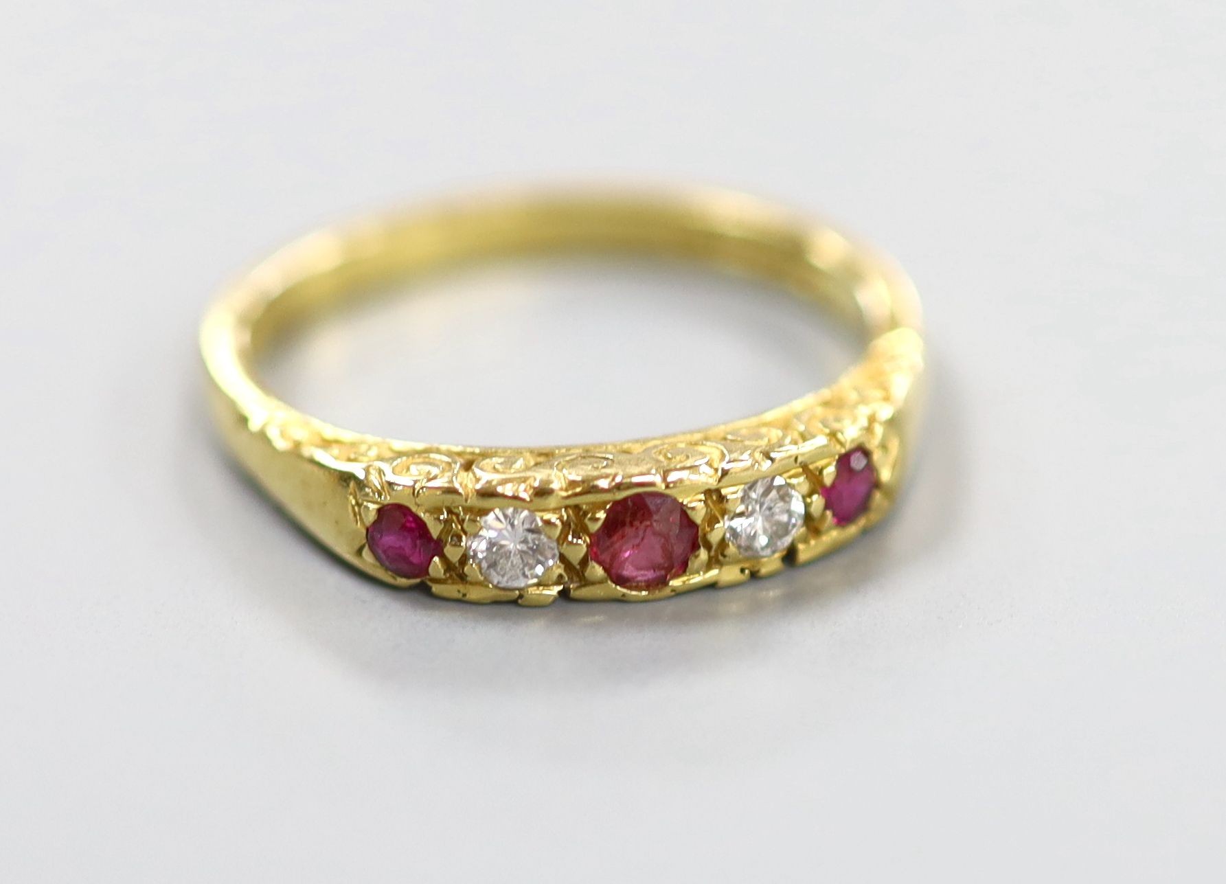 A modern 18ct gold, two stone diamond and three stone ruby half hoop ring, size O, gross weight 3.8 grams.